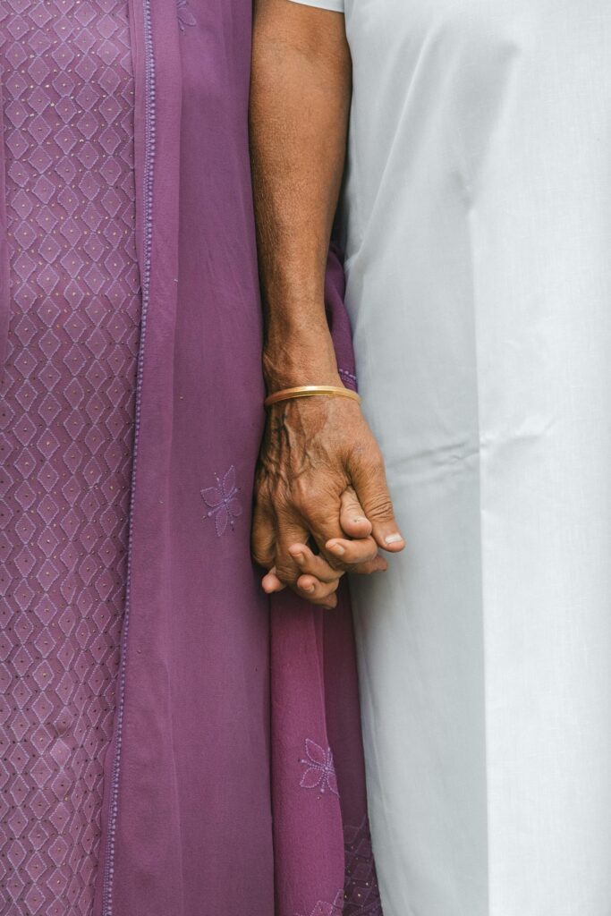 A caregiver holding the hand of a senior in their Keller home.