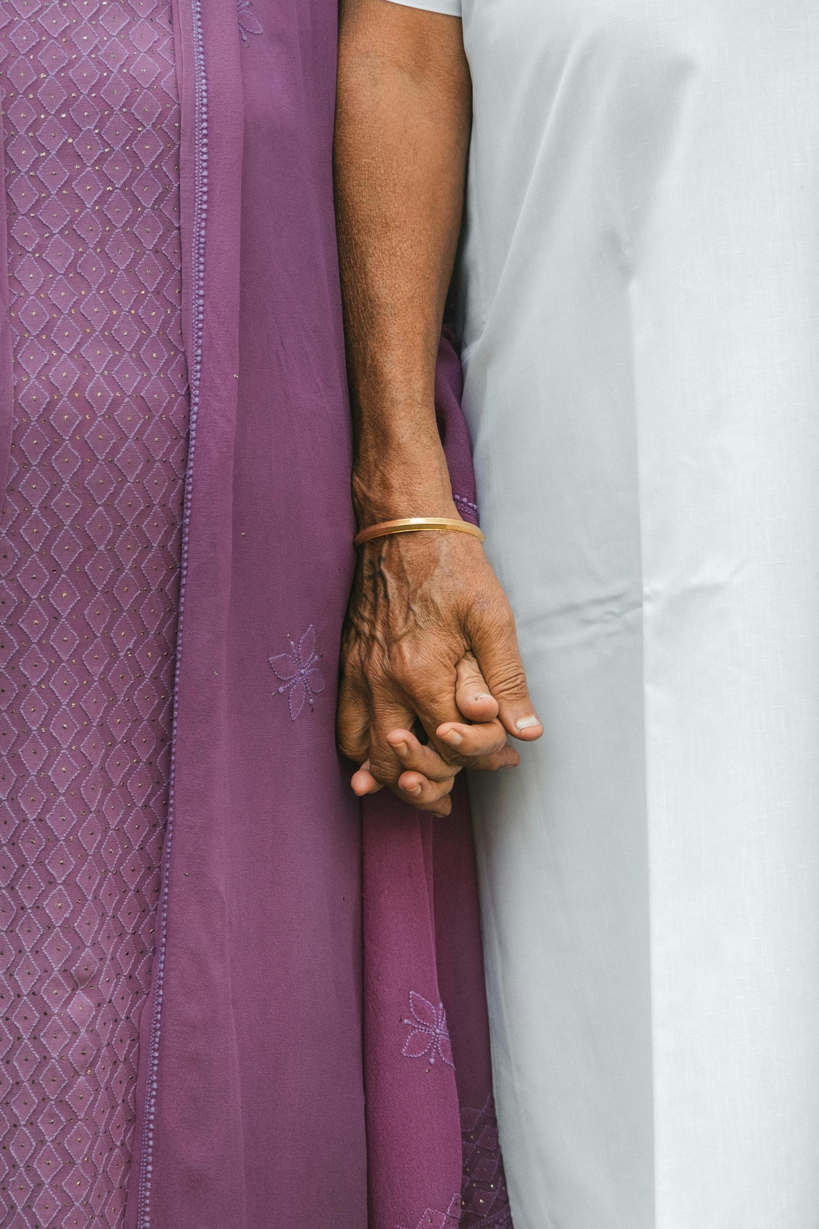 Close-up of elderly hands held together at home.